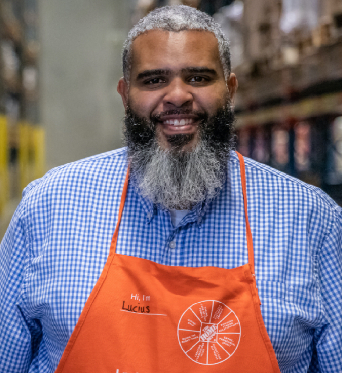 An Assistant General Manager smiles into the camera in a distribution center.